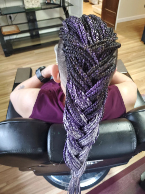 Purple feed-in braids styled into a long fishtail braid