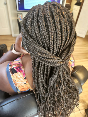 Medium box braids with curly ends.